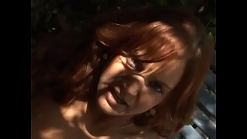 Playful redhaired hottie Gabriella Banks took off her lingerie to play with her muff rubbing it with glass dildo in the shade of a tree